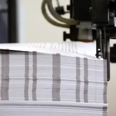 Stos papieru o wymiarach formatu a0 czeka na obróbkę w maszynie drukarskiej.