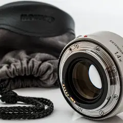 Canon Extender EF 1.4x III, czyli telekonwerter, gotowy do pracy. Obok miękki futerał z logo Canon.