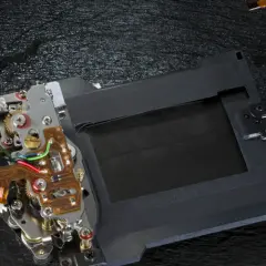 Mechanizm migawki szczelinowej aparatu z taśmami flex i elementami elektronicznymi.