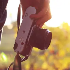 Dłoń trzyma aparat fotograficzny. Warto pomyśleć o ubezpieczeniu aparatu fotograficznego, by chronić swój sprzęt.