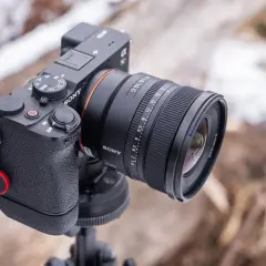 Sony A290 z obiektywem FE 1.8/16 G na statywie, w tle zimowy krajobraz.
