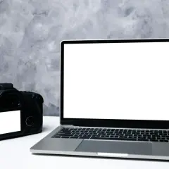 Aparat fotograficzny i laptop z pustym ekranem, gotowe do transferu zdjęć. Dowiedz się, jak zgrać zdjęcia z aparatu na komputer.
