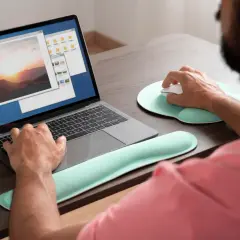 Mężczyzna pracuje na laptopie, przeglądając zdjęcia. Może szukać sposobu, jak wyostrzyć zdjęcie, aby poprawić jego jakość.