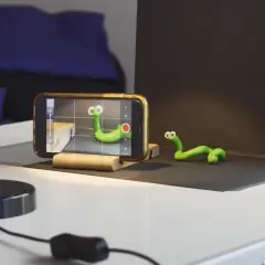 Tworzenie zielonych robaczków do animacji poklatkowej. Telefon nagrywa, ręka reguluje lampę.