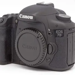 Czarny aparat Canon EOS 7D z obiektywem na białym tle.