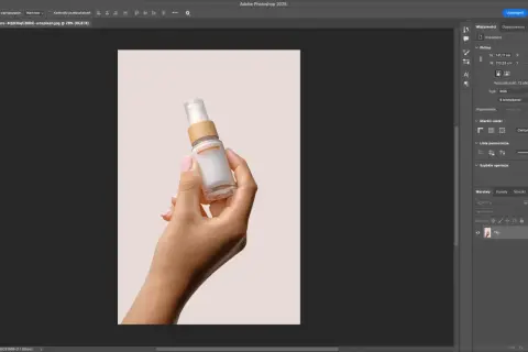 Dłoń trzymająca buteleczkę kosmetyku na jasnym tle. Program Photoshop pokazuje narzędzia, jak usunąć tło ze zdjęcia, aby wyizolować produkt.