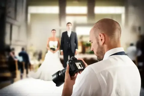 Fotograf uchwycił parę młodą, przygotowując się do sesji. Zastanawiasz się, ile kosztuje fotograf na wesele?