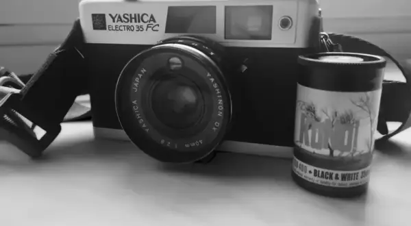 Stary aparat Yashica Electro 35 FC z obiektywem i rolką filmu czarno-białego "KONO!" 400. Klasyczny negatyw.