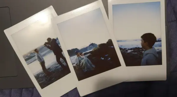 Trzy zdjęcia jak z instaxa: chłopcy na plaży, para na skałach i chłopiec patrzący na morze.