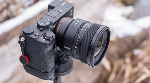 Sony A290 z obiektywem FE 1.8/16 G na statywie, w tle zimowy krajobraz.