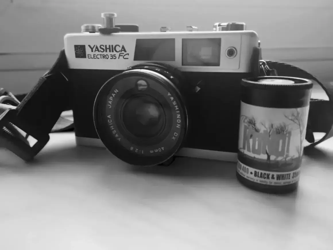 Stary aparat Yashica Electro 35 FC z obiektywem i rolką filmu czarno-białego "KONO!" 400. Klasyczny negatyw.