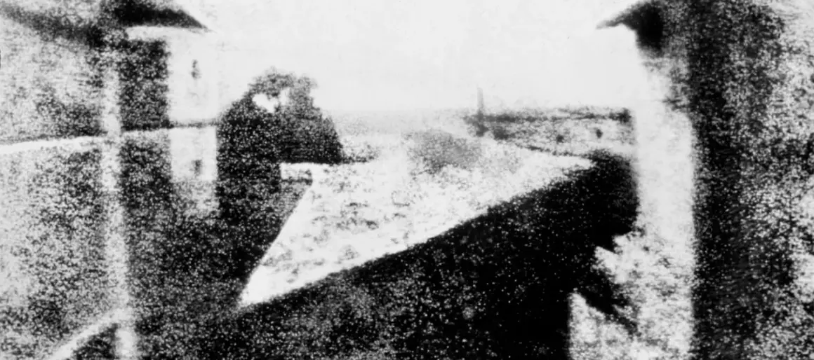 Pierwsze zdjęcie świata, kiedy wynaleziono fotografię. Widok z okna na ulicę, z sylwetką człowieka.