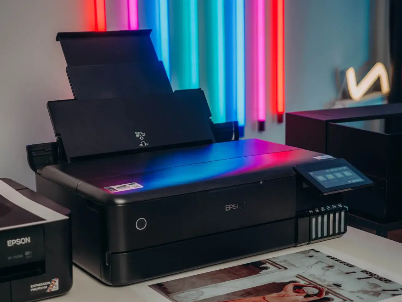 Nowoczesna drukarka Epson, która zapewnia wydruk wysokiej jakości fotograficznej, stoi obok starszego modelu.