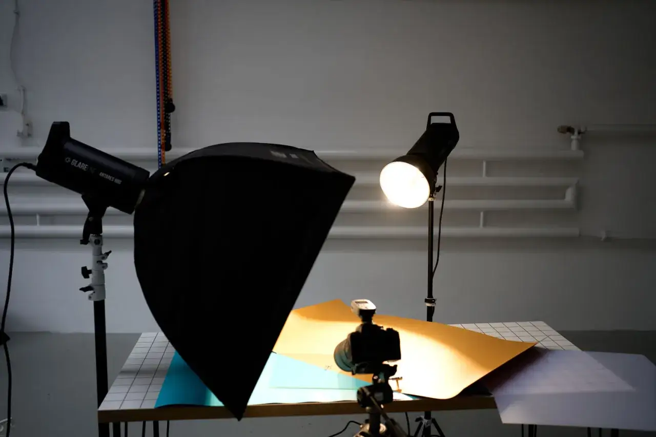 Studio setup do fotografii produktowej: lampy, softbox, aparat na statywie i kolorowe tła. Idealny flat lay do sesji.