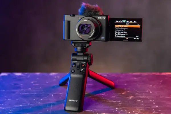Nowoczesne bezlusterkowce Sony na statywie z mikrofonem. Ekran pokazuje menu sieciowe, idealne do vlogowania.