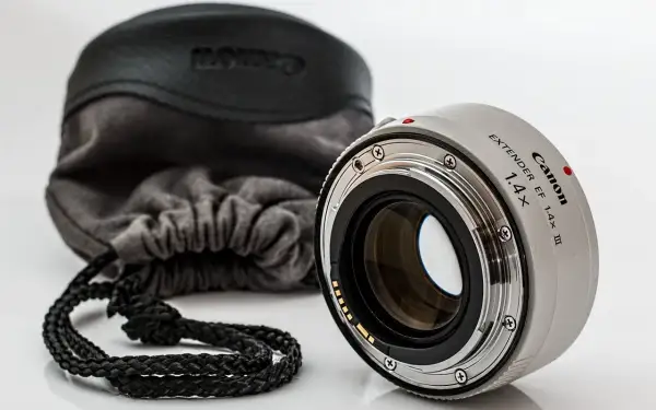 Canon Extender EF 1.4x III, czyli telekonwerter, gotowy do pracy. Obok miękki futerał z logo Canon.