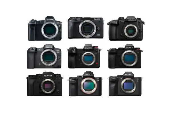 Dziewięć czarnych aparatów cyfrowych marek Canon, Nikon, Fujifilm i Sony na białym tle.