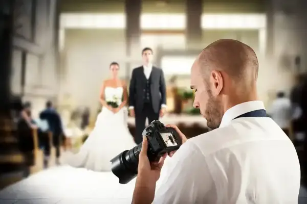 Fotograf uchwycił parę młodą, przygotowując się do sesji. Zastanawiasz się, ile kosztuje fotograf na wesele?