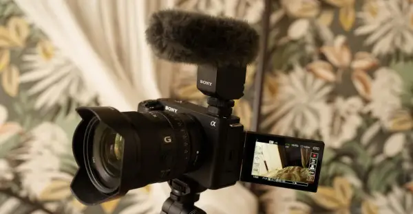 Kamera Sony Alpha z mikrofonem na gorącej stopce, gotowa do nagrywania. Idealny sprzęt do tworzenia treści, np. vlogów.